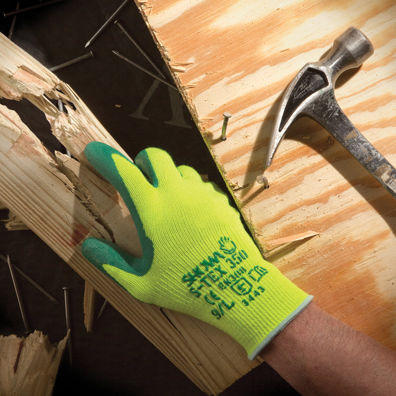 SHOWA S-TEX 350 bei der Handhabung eines Holzbretts, daneben ein Hammer